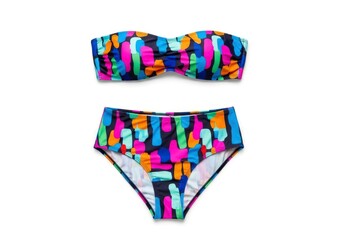 A two-piece swimsuit featuring a bandeau top and high-waisted bottom adorned with a vibrant abstract pattern of multicolored shapes on a dark background laid flat on white