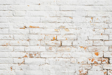 Aged whitewashed brick wall texture with flaking paint and exposed yellow surface.