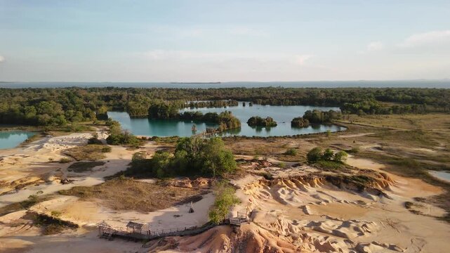 bintan islands blue lagoon also known as danau biru features striking turquoise waters surrounded by white sand hills creating a stunning contrast and serene tropical atmosphere