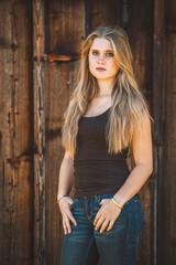 Fototapeta premium Junge blonde Frau / Holzhintergrund