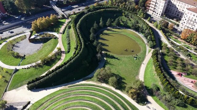 Cinematic aerial drone video of Portello Park in Milan, Italy. The footage features spiral hills,
