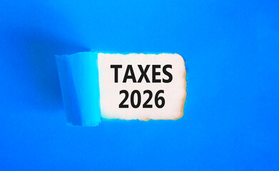 Taxes 2026 new year symbol. Concept words Taxes 2026 on beautiful blue paper. Beautiful yellow paper background. Business and taxes 2026 new year concept. Copy space.
