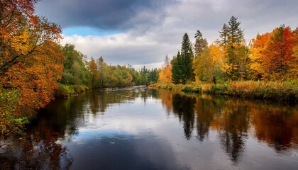 Fototapeta premium Tranquil River Reflecting Autumn Colors In A Forested Area During A Cloudy Afternoon