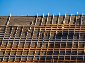 Roof construction grid pattern with clear blue sky background.