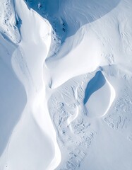 Aerial drone shot of snow-covered mountain patterns forming fractal geometry