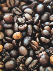 vertical macro close-up of dark roasted coffee beans texture with shallow depth of field