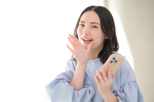 スマホを持って呼びかける日本人女性