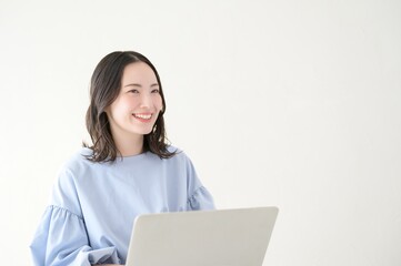 明るい部屋でパソコンを操作する日本人女性