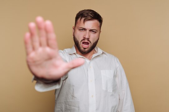 Man Making Stop Gesture in White Shirt