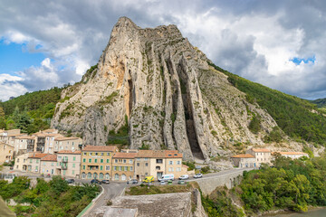 Picturesque town nestled beneath a dramatic mountain cliff. Sisteron, France