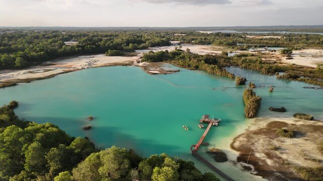 bintan islands blue lagoon also known as danau biru features striking turquoise waters surrounded by white sand hills creating a stunning contrast and serene tropical atmosphere