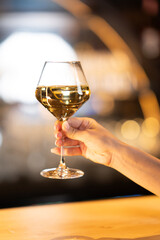 Hand holding a glass of white wine