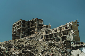Destroyed residential building surrounded by piles of debris because of demolition, earthquake, war...