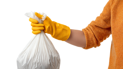 Person wearing yellow gloves holding a tied waste bag in a clean and organized environment.