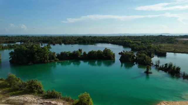 bintan islands blue lagoon also known as danau biru features striking turquoise waters surrounded by white sand hills creating a stunning contrast and serene tropical atmosphere