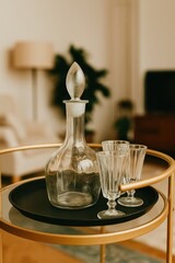Elegant glass decanter and vintage glasses on a golden serving tray
