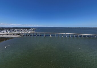 Aerial View Of Washington Baum Bridge Over Calm Water of Roanoke Sound Connecting Roanoke Island to Nags Head on the Outer Banks. Bright blue sky, tranquil water, urban-seaside scene.