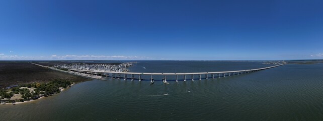 Aerial View Of Washington Baum Bridge Over Calm Water of Roanoke Sound Connecting Roanoke Island to Nags Head on the Outer Banks. Bright blue sky, tranquil water, urban-seaside scene.