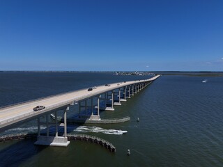 Aerial View Of Washington Baum Bridge Over Calm Water of Roanoke Sound Connecting Roanoke Island to Nags Head on the Outer Banks. Bright blue sky, tranquil water, urban-seaside scene.