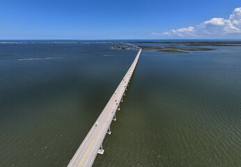 Aerial View Of Washington Baum Bridge Over Calm Water of Roanoke Sound Connecting Roanoke Island to Nags Head on the Outer Banks. Bright blue sky, tranquil water, urban-seaside scene.