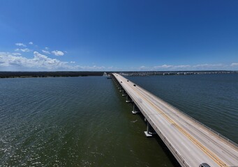 Aerial View Of Washington Baum Bridge Over Calm Water of Roanoke Sound Connecting Roanoke Island to Nags Head on the Outer Banks. Bright blue sky, tranquil water, urban-seaside scene.