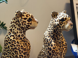 Two leopard figurines with detailed spotted patterns under soft light. Artistic wildlife decor, symmetry and natural inspiration in modern interior design.