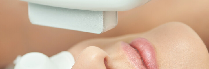 Female asian adult undergoing modern cosmetic treatment with advanced technology.