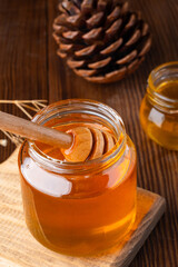 Honey jar and  honey dipper  on wooden background