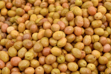 Fresh green olives piled in brine closeup