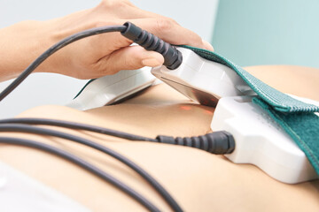 Close-up of female receiving non-invasive laser treatment for body contouring and fat reduction...