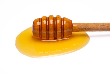 Honey dripping from honey dipper  on white background