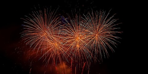 Three orange fireworks bursting against black night sky
