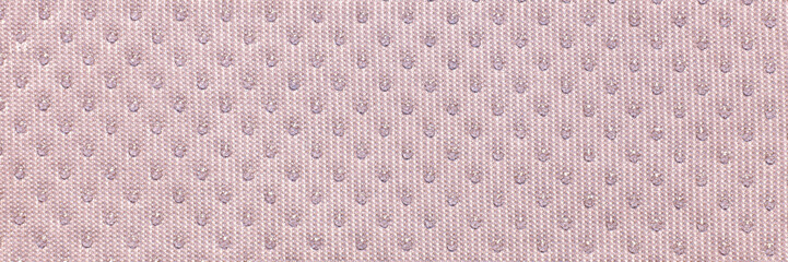 Textured beige fabric close-up with subtle pattern of small dots creating elegant surface design.