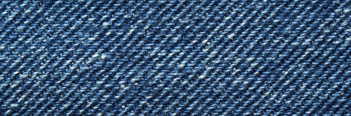 Close-up of blue denim fabric texture with detailed weave pattern and stitching design in high resolution.