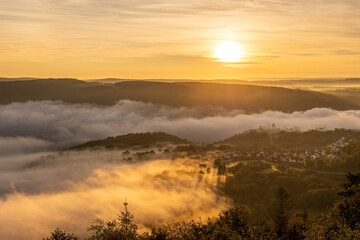 Sunrise over the Rhine River near Bad Salzig in Germany creates a stunning landscape with mist and golden hues