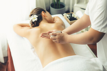 Masseur hands pouring aroma oil on woman back. Masseuse prepare oil massage procedure for customer...