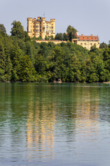 Experience the stunning view of Hohenschwangau Castle surrounded by lush nature in the German Alps