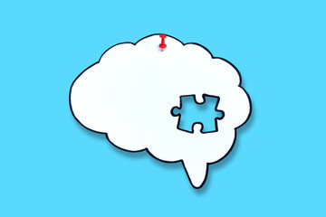 Missing puzzle piece of brain symbol on blue background. Mental health and problems with memory.