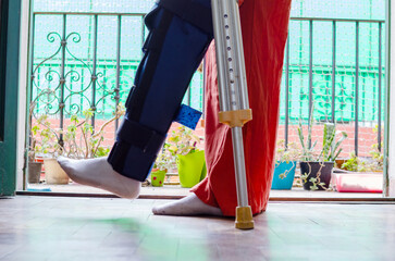 Close up of a young disabled woman using crutches doing rehabilitation exercises.Broken leg.