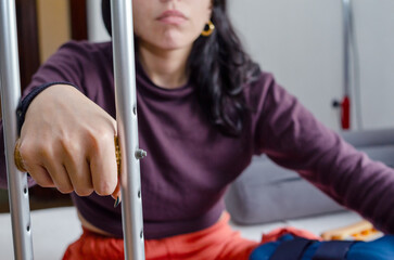 Close up hand of a young woman holding a crutch.