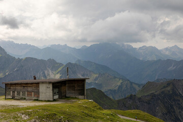 Old rustic building on Nebelhorn with stunning mountain views surrounded by the German Alps on a cloudy day