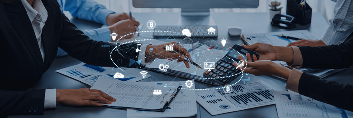 Professional business team engages in financial analysis using technology tools, showcasing teamwork and collaboration in a modern office environment. Trope