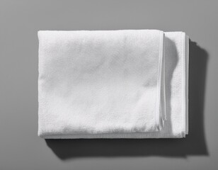 Crisp White Terry Towels Neatly Folded on a Light Gray Surface, Presenting a Clean and Minimalist Aesthetic