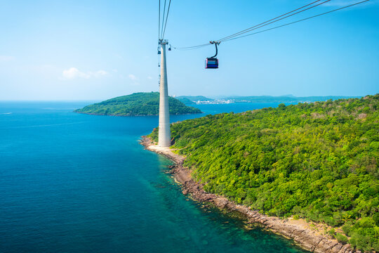 Longest Hon Thom cable car crossing over turquoise sea and lush green hills in Phu Quoc island, Vietnam. Cable car support tower with cable car cabin above tropical ocean. Modern tourism technology