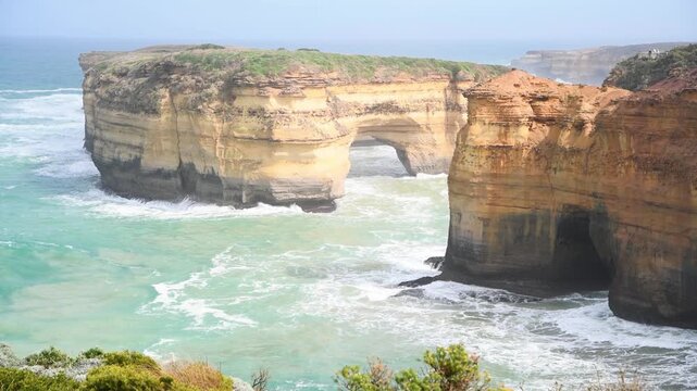 Loch Ard Gorge with turquoise water and golden cliffs under bright sunlight in Australia