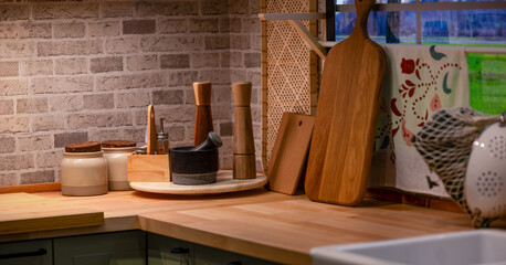 Warm Modern Kitchen Counter with Wooden Utensils and Ceramic Storage Containers Against Exposed Brick Wall