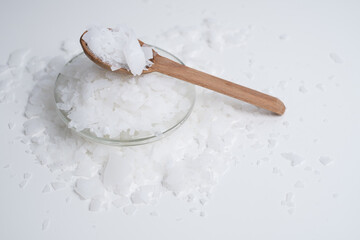 Close-up of magnesium salt flakes. Spa body care and magnesium therapy. White salt, cotton towels, eco-friendly products for home relaxation spa.