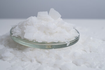 Close-up of magnesium salt flakes. Spa body care and magnesium therapy. White salt, cotton towels, eco-friendly products for home relaxation spa.
