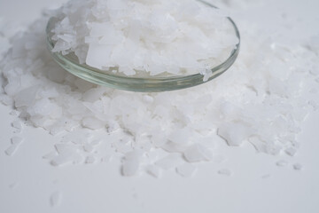 Close-up of magnesium salt flakes. Spa body care and magnesium therapy. White salt, cotton towels, eco-friendly products for home relaxation spa.