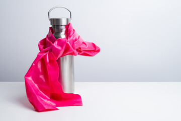 Stainless steel water bottle with colorful resistance bands and massage ball on a light background. Set of gym and home workout accessories for fitness and healthy lifestyle concepts.